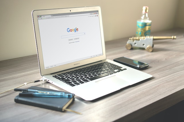 Laptop sitting on a desk open to the Google search page